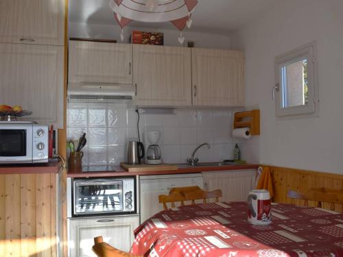une petite cuisine avec une table et un micro-ondes dans l'établissement Appartement 2 pièces cabine, plein sud, balcon, parking, à 800m du centre de Font-Romeu - FR-1-580-80, à Font-Romeu-Odeillo-Via