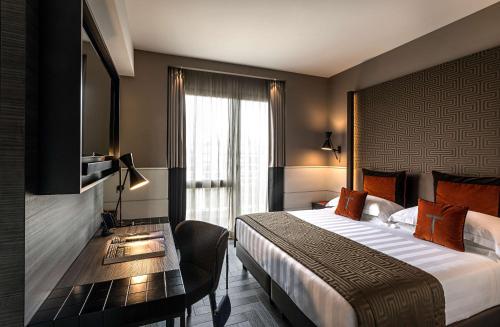 una camera d'albergo con letto, scrivania e TV di The Tribune, part of JdV by Hyatt a Roma