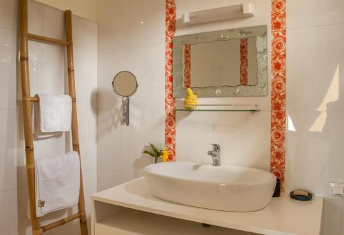 a white bathroom with a sink and a mirror at La Villa 126 in Dakar