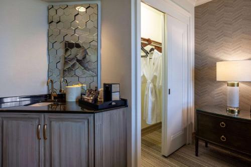 ein Badezimmer mit einem Waschtisch, einem Waschbecken und einem Spiegel in der Unterkunft Grandover Resort & Spa, a Wyndham Grand Hotel in Greensboro