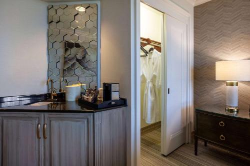 a bathroom with a vanity with a sink and a mirror at Grandover Resort & Spa, a Wyndham Grand Hotel in Greensboro