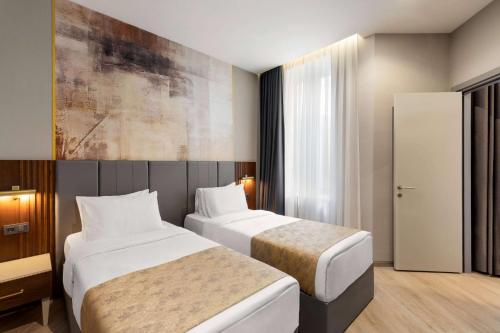 a hotel room with two beds and a window at Tbilisi Chambers, Trademark Collection by Wyndham in Tbilisi City