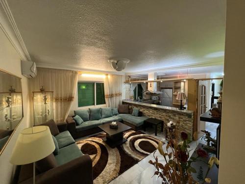 een woonkamer met een bank en een tafel bij Apartment in Shmaisani in Amman
