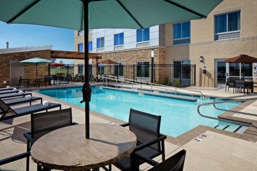 a pool with a table and chairs and an umbrella at Stone Hill Norman, Trademark Collection by Wyndham in Norman