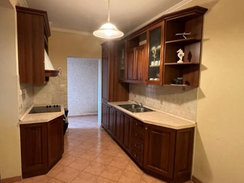 a kitchen with wooden cabinets and a sink at Mira in Barbat na Rabu