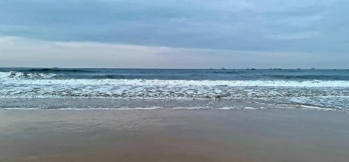 a beach with the ocean in the background at Ronaldos Hotel & Restaurants Baga in Old Goa