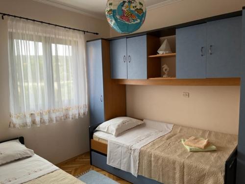 a bedroom with two beds and a window at Mira in Barbat na Rabu