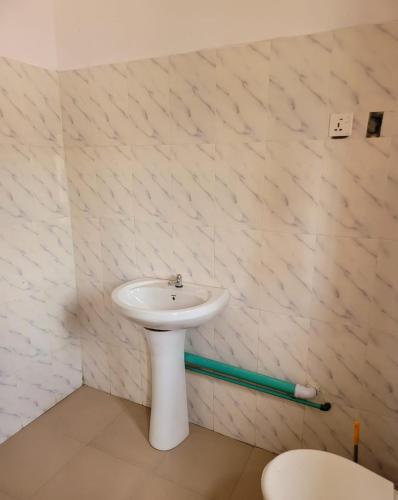 uma casa de banho com um lavatório branco num quarto em Eko Akete Guest House em Abeokuta