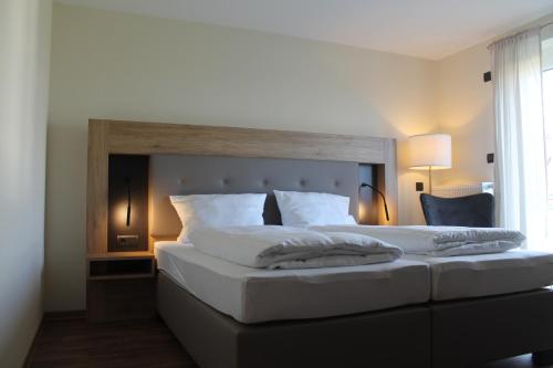 a bedroom with a large bed with a wooden headboard at Träbeser Bauernstube in Meiningen