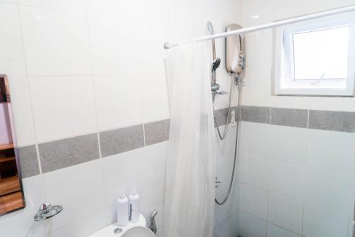 La salle de bains est pourvue d'une douche et de toilettes. dans l'établissement OKEANOS HOTEL, à Moalboal