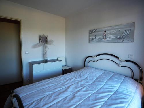 a bedroom with a bed and a picture of a beach at Appartement Arcachon, 2 pièces, 4 personnes - FR-1-474-32 in Arcachon