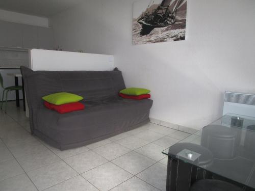 - un salon avec un canapé et des oreillers verts et rouges dans l'établissement Appartement moderne avec terrasse à 100m de la plage des Sables-d'Olonne - FR-1-197-405, à Les Sables-dʼOlonne