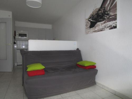 - un canapé dans le salon avec des oreillers verts et rouges dans l'établissement Appartement moderne avec terrasse à 100m de la plage des Sables-d'Olonne - FR-1-197-405, à Les Sables-dʼOlonne