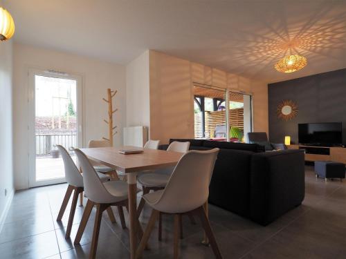 une salle à manger et un salon avec une table et des chaises dans l'établissement Bel Appartement Proche Centre Ville avec Terrasse et Parking pour 6 Personnes à Arcachon - FR-1-474-63, à Arcachon