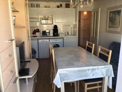 une cuisine avec une table et des chaises dans une cuisine dans l'établissement Appartement T2 cabine à 2 min de la plage avec parking privatif à Fort-Mahon - FR-1-482-6, à Fort-Mahon-Plage