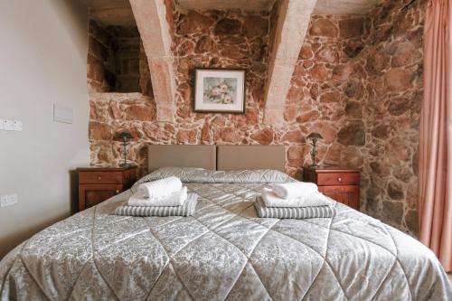 a bedroom with a large bed in a stone wall at Ta'Filomena in Xagħra