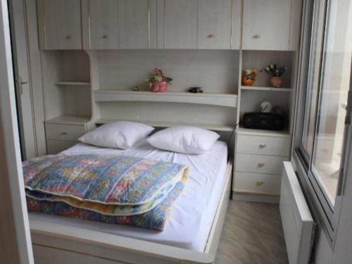 Cette petite chambre comprend un lit avec des placards blancs. dans l'établissement Charmant T2 à Fort-Mahon-Plage, à deux pas de la plage et du club de voile, parking inclus - FR-1-482-2, à Fort-Mahon-Plage