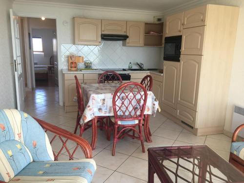 une cuisine avec une table et des chaises dans une pièce dans l'établissement Fort-Mahon-Plage : Confortable appartement 2 chambres près de la plage - FR-1-482-5, à Fort-Mahon-Plage