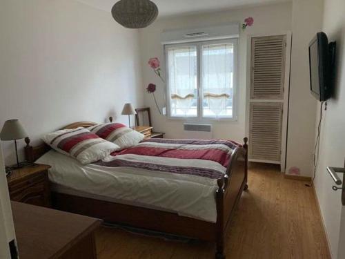 a bedroom with a bed with a window and a television at Appartement Fort-Mahon-Plage, 2 pièces, 4 personnes - FR-1-482-15 in Fort-Mahon-Plage