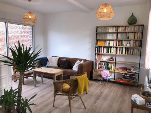 a living room with a couch and a table at Maison de pêcheur+ jardin 5 min à pieds de la Baie in Le Crotoy