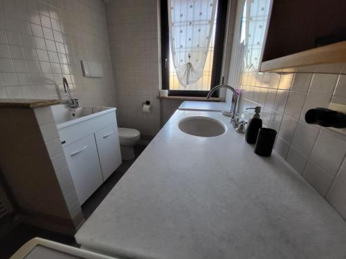 bagno bianco con lavandino e servizi igienici di Villa Ghiaia locazione turistica a Castel d'Azzano