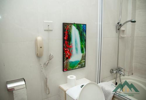 uma casa de banho branca com um lavatório e um telefone em Ange Hill Hotel em Acra