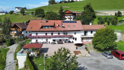 an aerial view of a large house with a parking lot at Pension Wirt am Bach in Terento