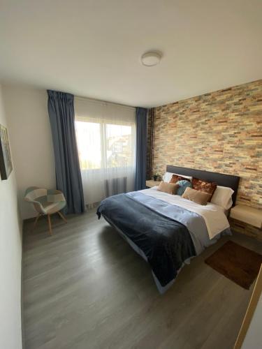 a bedroom with a large bed and a brick wall at Precioso piso en el centro de Galicia. in Silleda