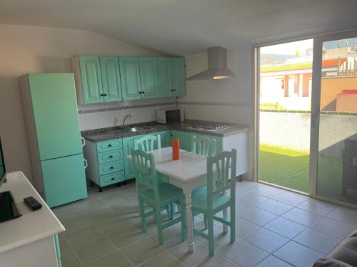 a kitchen with green cabinets and a table and chairs at La Arena VII in Los Abrigos