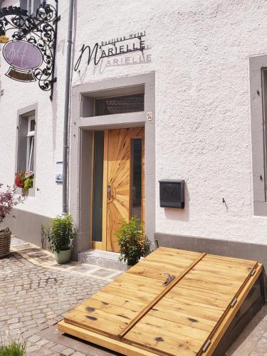 a wooden table in front of a building with a door at Boutique Hotel Marielle in Bad Münstereifel