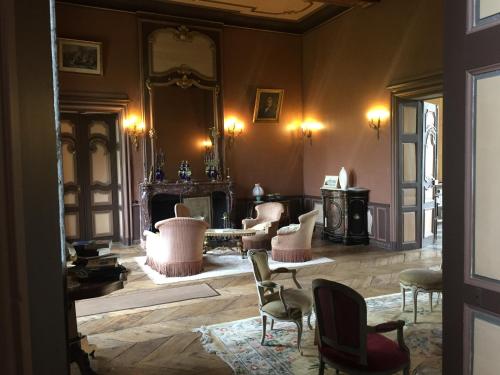 Habitación con sillas, mesa y espejo. en Château de Couin, en Couin