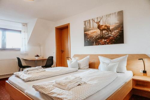 2 Betten in einem Zimmer mit Hirschmalerei an der Wand in der Unterkunft Gasthaus Hirsch in Wangen im Allgäu