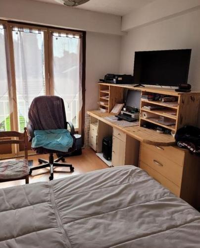 Schlafzimmer mit einem Schreibtisch, einem Computer und einem Stuhl in der Unterkunft Appartement f2 in Saint-Quentin