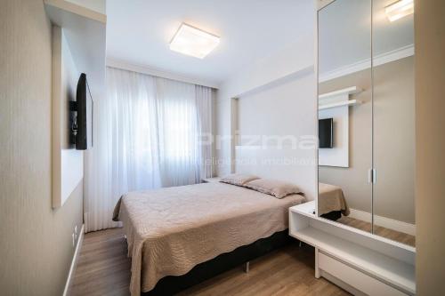 Schlafzimmer mit einem Bett und einem Spiegel in der Unterkunft Varandas 405 A · Apartamento em Condomínio de luxo frente ao mar . in Bombinhas