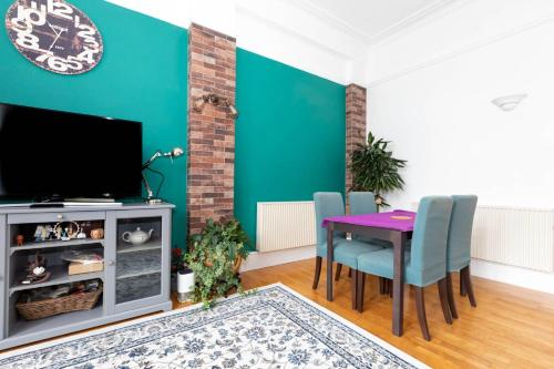 a living room with a table and chairs and a tv at Central 2 Bedroom Apartment near Old Street in London