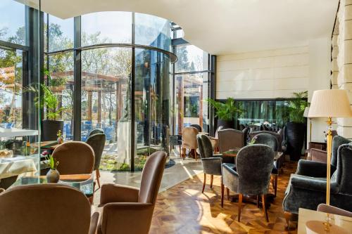 a lobby with chairs and tables and windows at Hotel Park Split in Split
