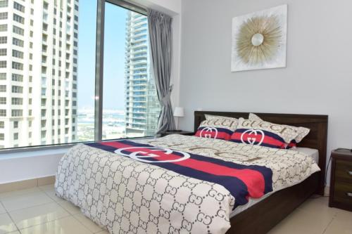 1 dormitorio con cama y ventana grande en 1 BEDROOM APARTMENT in DUBAI MARINA & JBR, en Dubái