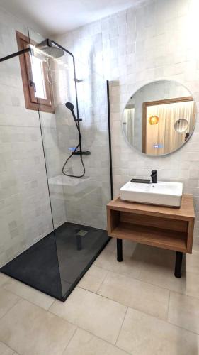 a bathroom with a sink and a shower with a mirror at Intense Boutik-Hôtel in Port-Vendres