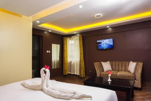 una habitación de hotel con una cama con un cisne en ella en Sahara Gardens Bomet, en Bomet