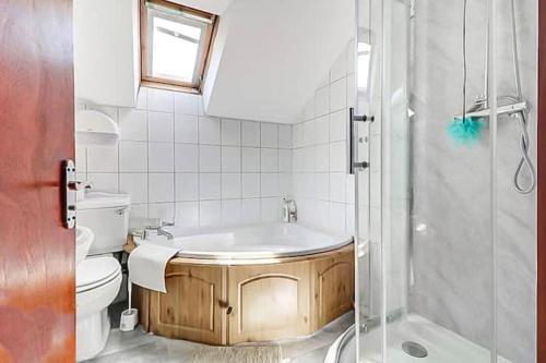 a bathroom with a tub and a toilet and a shower at Detached bungalow with 7 bedrooms in Luton