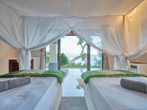 2 Betten in einem Zimmer mit Fenster in der Unterkunft Anda Amed Villas & Spa in Amed