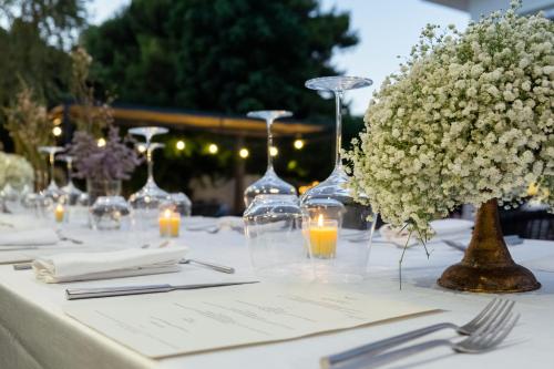 a table with white flowers and wine glasses on it at Domìa Boutique Hotel e Cucina in Mondello