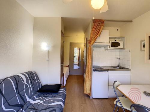 uma sala de estar com um sofá e uma cozinha em Studio Lamalou-les-Bains, 1 pièce, 2 personnes - FR-1-451-76 em Lamalou-les-Bains