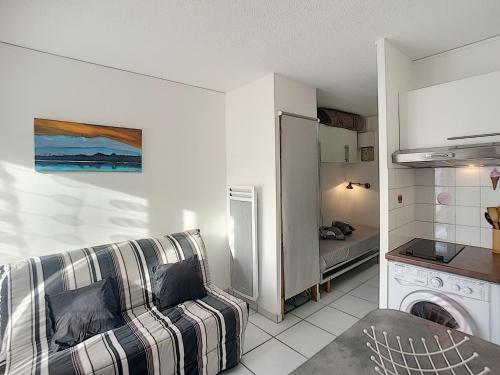 un salon avec un canapé et une cuisine dans l'établissement Studio rénové avec balcon, animaux acceptés, wifi, à 650m des Thermes - FR-1-451-92, à Lamalou-les-Bains