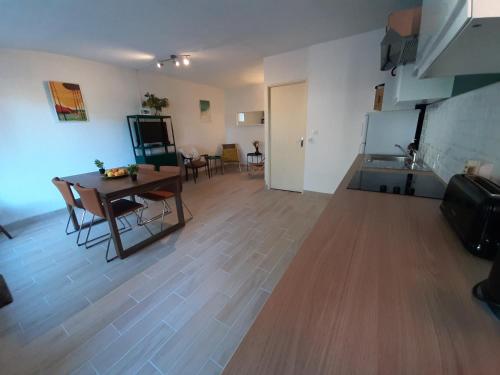 - un salon avec une table, une cuisine, une table et des chaises dans l'établissement Maison rénovée avec terrasse à 700m des plages, marché et activités - Tennis et piste cyclable à 10m - FR-1-239-385, à Seignosse