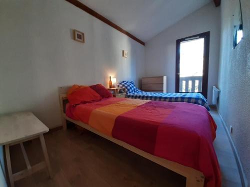 a bedroom with a large bed with a colorful bedspread at Maison Seignosse, 3 pièces, 4 personnes - FR-1-239-385 in Seignosse