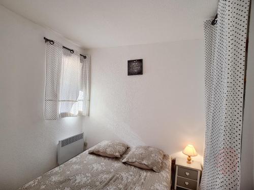 - une chambre avec un lit et une lampe sur une table de chevet dans l'établissement Appart F2 avec terrasse, parking et wifi à Lamalou - FR-1-451-107, à Lamalou-les-Bains