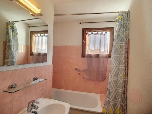 La salle de bains est pourvue d'un lavabo, d'une baignoire et d'une douche. dans l'établissement Appartement Lamalou-les-Bains, 2 pièces, 2 personnes - FR-1-451-107, à Lamalou-les-Bains