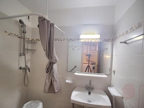 une salle de bain avec un lavabo, des toilettes et une douche dans l'établissement Charmant appartement avec terrasse, parking gratuit et animaux acceptés, proche des thermes à Lamalou - FR-1-451-89, à Lamalou-les-Bains