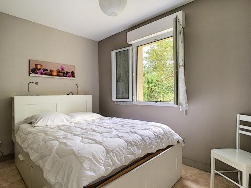 um quarto com uma cama e uma janela em Maison Crozon, 3 pièces, 4 personnes - FR-1-370-42 em Crozon